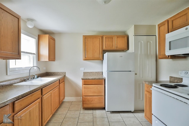 kitchen with white appliances, a sink, baseboards, and light tile patterned floors