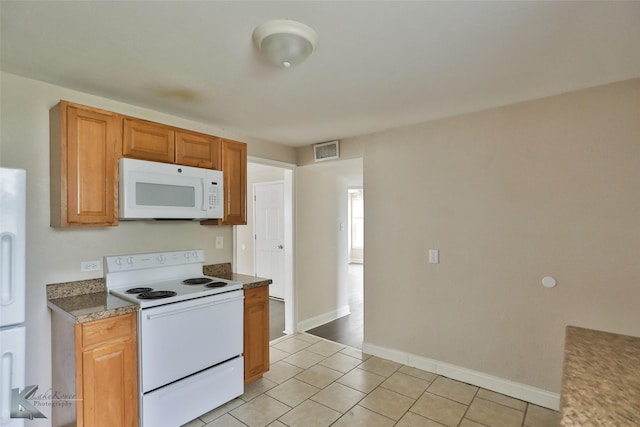 kitchen with light tile patterned floors, white appliances, visible vents, baseboards, and brown cabinetry