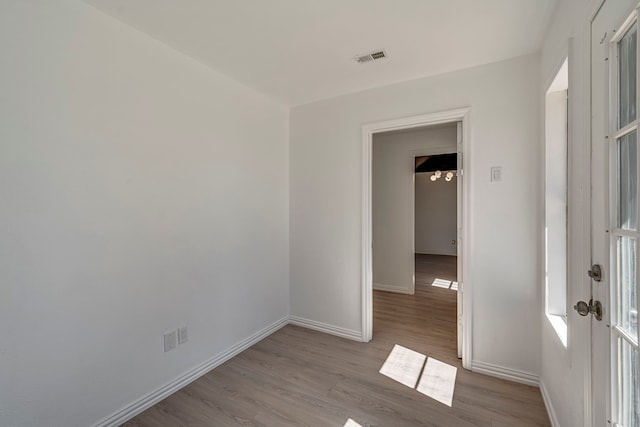 empty room featuring visible vents, baseboards, wood finished floors, and french doors