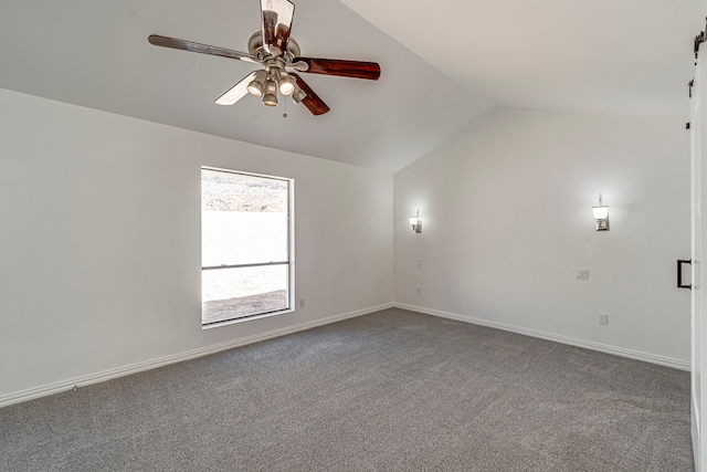 carpeted spare room featuring vaulted ceiling, a ceiling fan, and baseboards