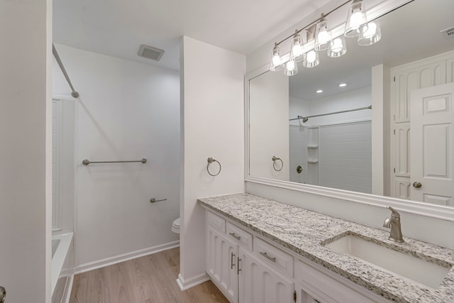 full bath with toilet, visible vents, wood finished floors, and vanity