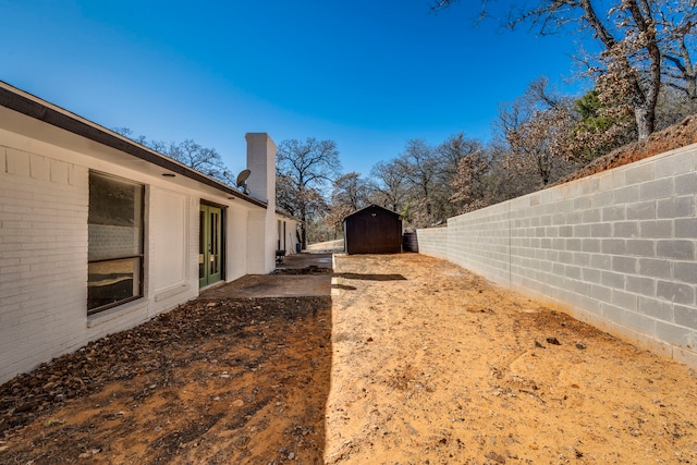 view of yard featuring a shed, an outdoor structure, and a fenced backyard