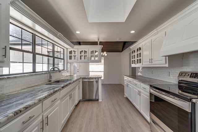 kitchen featuring stainless steel appliances, a sink, and white cabinetry