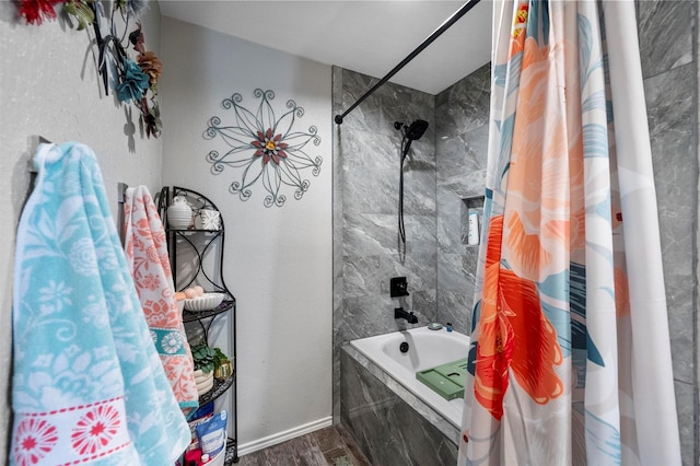 bathroom with tiled shower / bath combo, wood finished floors, and baseboards