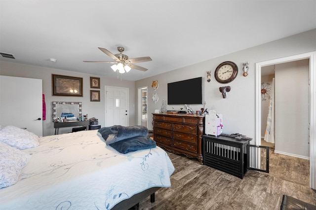 bedroom with visible vents, a ceiling fan, and wood finished floors