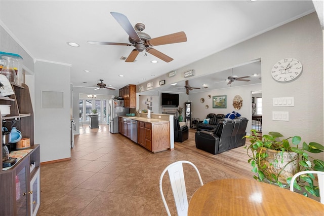 kitchen featuring brown cabinetry, appliances with stainless steel finishes, open floor plan, light countertops, and light tile patterned flooring