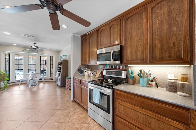 kitchen featuring brown cabinets, light tile patterned floors, stainless steel appliances, tasteful backsplash, and visible vents