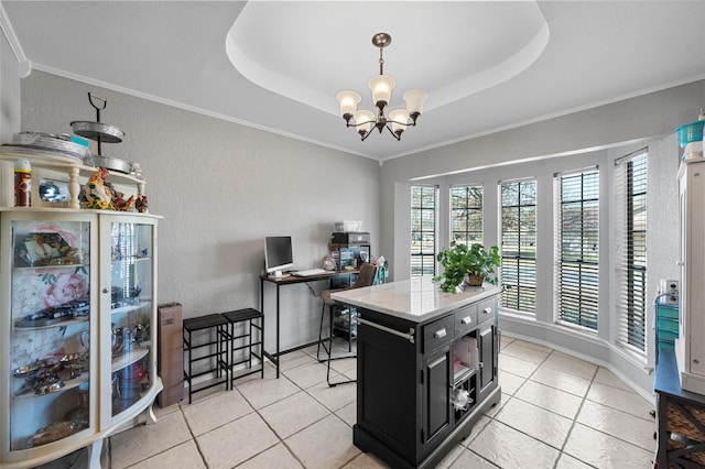 kitchen with dark cabinets, a tray ceiling, a notable chandelier, and ornamental molding