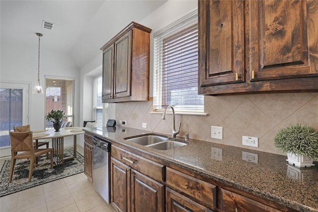 kitchen featuring visible vents, dark stone counters, dishwasher, lofted ceiling, and a sink