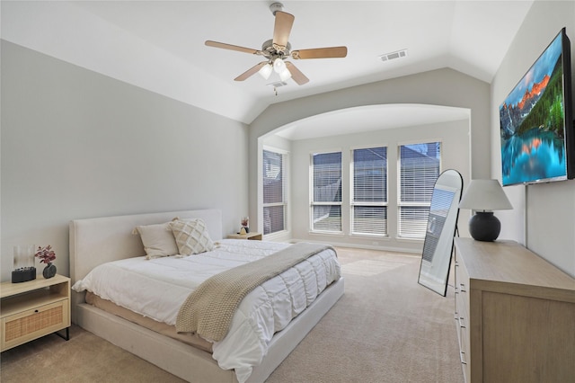 bedroom featuring lofted ceiling, light carpet, visible vents, and a ceiling fan