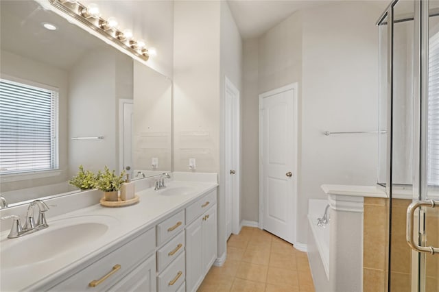 bathroom with double vanity, a garden tub, tile patterned flooring, and a sink