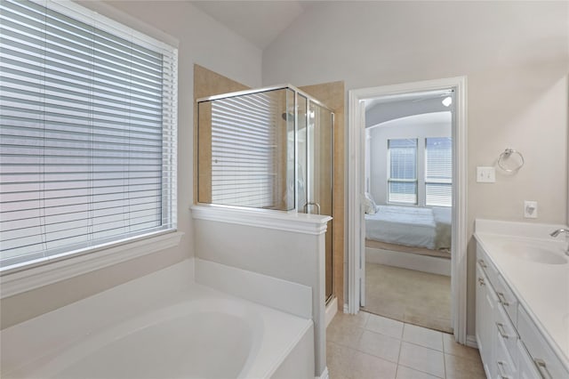 ensuite bathroom featuring tile patterned floors, a stall shower, vaulted ceiling, vanity, and a bath