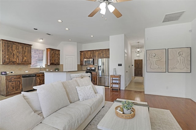 living room with baseboards, visible vents, ceiling fan, wood finished floors, and recessed lighting