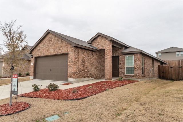 view of front of house featuring a garage, brick siding, driveway, and fence