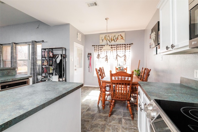 dining room featuring visible vents and dark tile patterned flooring