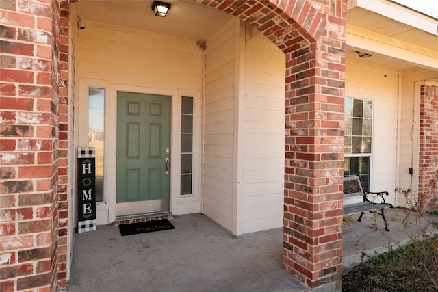 view of exterior entry with brick siding