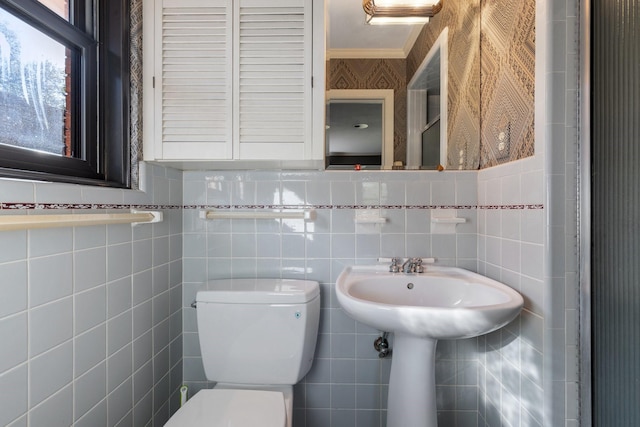 half bath with ornamental molding, toilet, and wallpapered walls