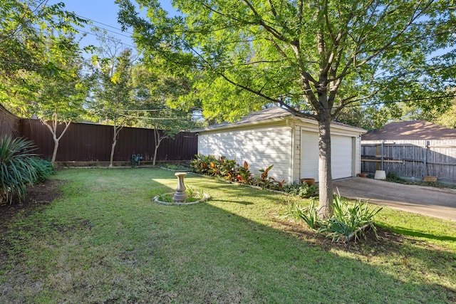 view of yard with a fenced backyard, an outdoor structure, and a detached garage