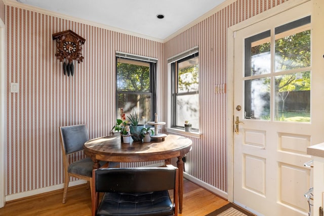 dining space with light wood-style floors, baseboards, and wallpapered walls