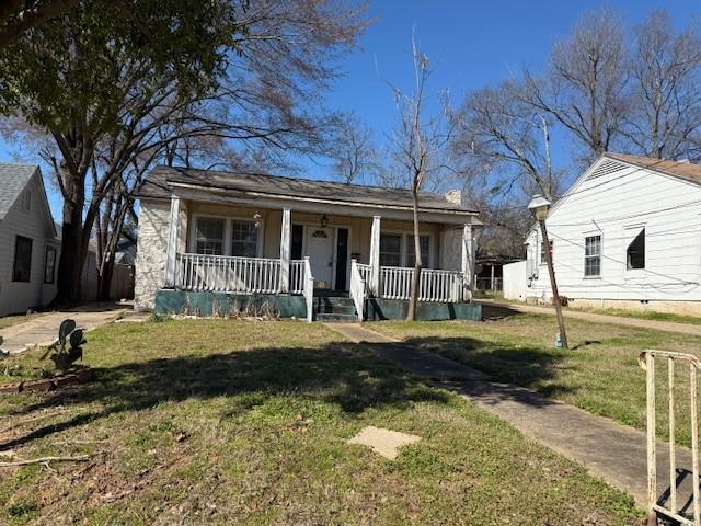 bungalow-style home with covered porch and a front lawn