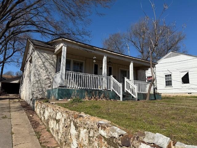 view of front facade with covered porch and a front yard