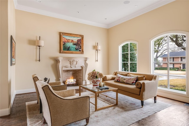 sitting room featuring ornamental molding, a high end fireplace, baseboards, and wood finished floors