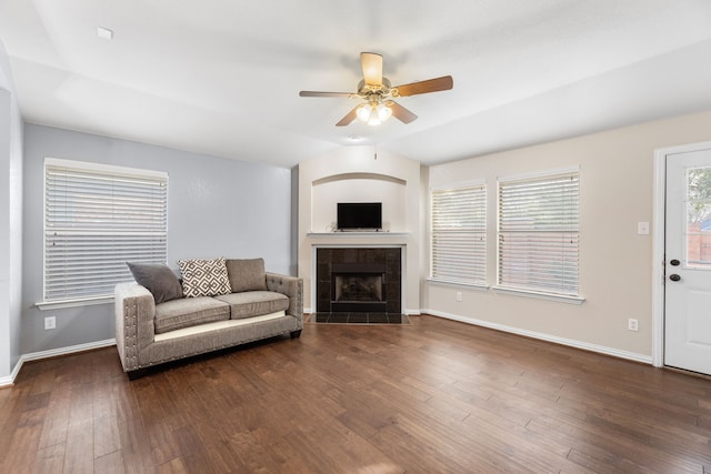 living area with hardwood / wood-style flooring, a fireplace, a ceiling fan, baseboards, and vaulted ceiling