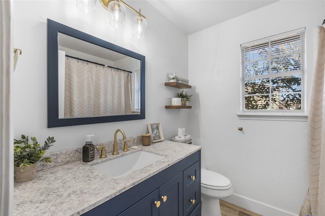 bathroom featuring wood finished floors, vanity, toilet, and baseboards