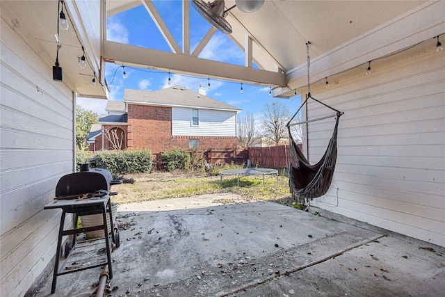 view of patio / terrace with a trampoline, fence, and area for grilling