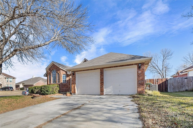 view of front of property with concrete driveway, brick siding, fence, and an attached garage