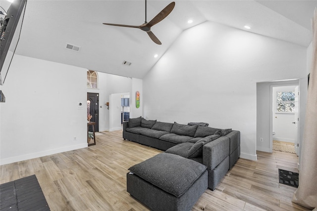 living area featuring high vaulted ceiling, visible vents, and light wood finished floors