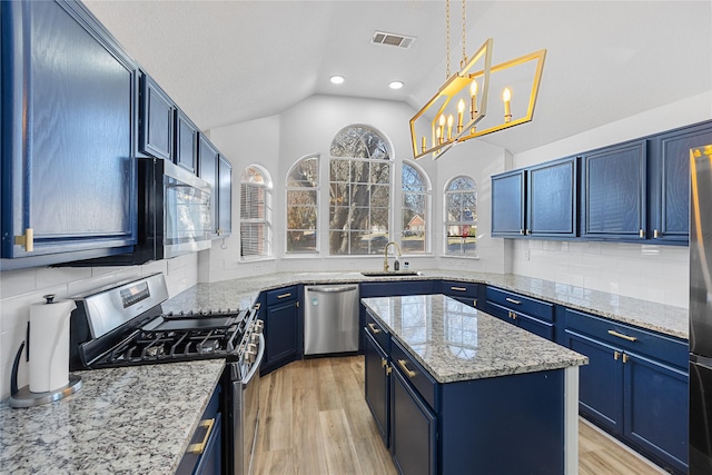 kitchen featuring a center island, blue cabinetry, stainless steel appliances, vaulted ceiling, and a sink