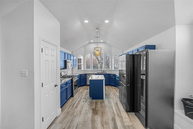 kitchen with lofted ceiling, blue cabinets, a sink, appliances with stainless steel finishes, and light wood-type flooring