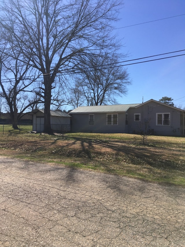 view of front of home featuring metal roof and an outdoor structure