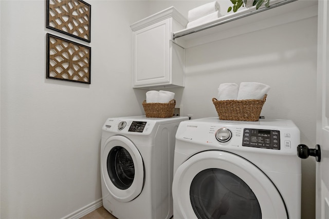 washroom with cabinet space, washing machine and dryer, and baseboards