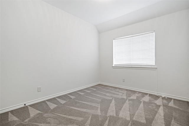 carpeted spare room with lofted ceiling and baseboards