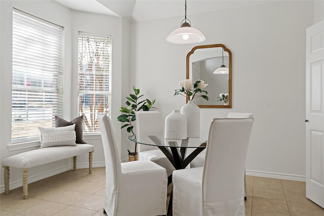 tiled dining space featuring baseboards