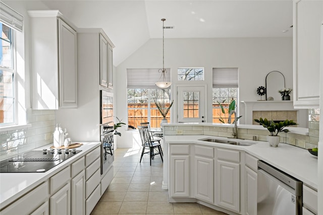 kitchen with light tile patterned floors, stainless steel appliances, a sink, light countertops, and decorative backsplash