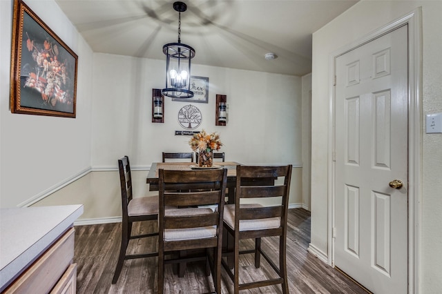 dining room with dark wood-style floors, a notable chandelier, and baseboards