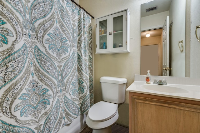 bathroom featuring toilet, vanity, visible vents, and a shower with curtain