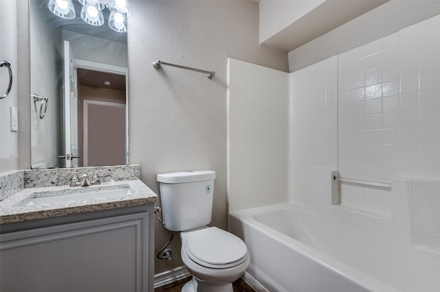 bathroom with a textured wall, vanity, and toilet