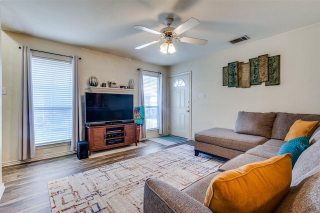 living area featuring wood finished floors, visible vents, and a ceiling fan