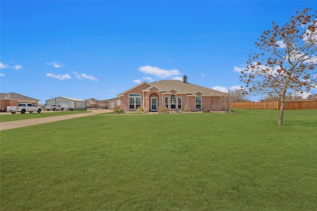 ranch-style home featuring driveway, a front lawn, a chimney, and fence