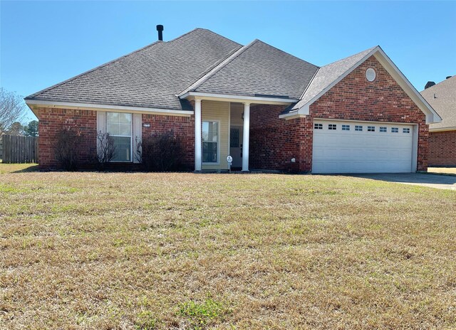 view of front facade featuring brick siding, a front lawn, and a shingled roof