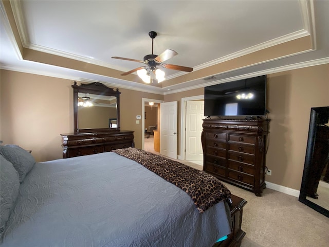 carpeted bedroom featuring a ceiling fan, a tray ceiling, and crown molding