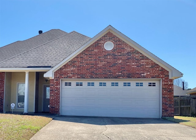 view of front of property featuring driveway, fence, brick siding, and roof with shingles