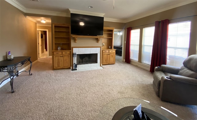 living area with light carpet, ceiling fan, crown molding, and a tile fireplace