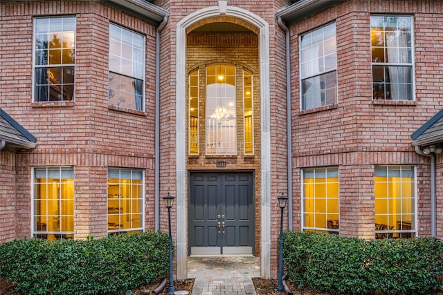 view of exterior entry with brick siding