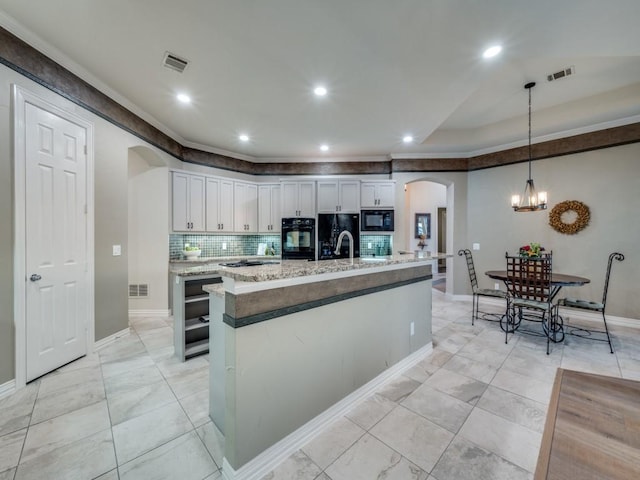 kitchen featuring arched walkways, visible vents, crown molding, and black appliances