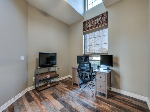 office with a towering ceiling, baseboards, and dark wood finished floors